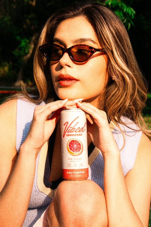 Vibed seltzer held up against a sunny sky